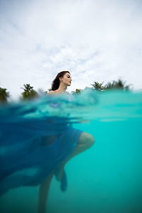 woman in body of water under white clouds thumbnail