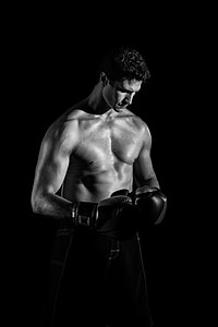 grayscale photography of topless man wearing gloves thumbnail