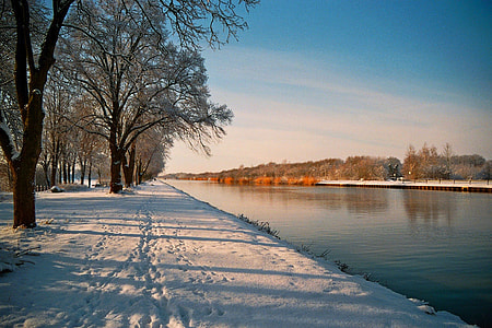 snow-covered field near body of water thumbnail