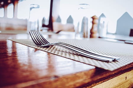 Two Stainless Steel Forks on Top of Place Mat thumbnail