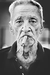 man biting tobacco in grayscale photo thumbnail
