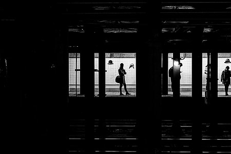 silhouette photography of two men beside wall thumbnail