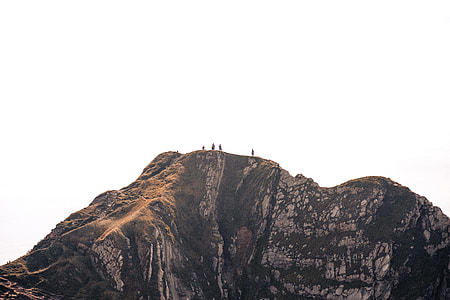 four people on peak of mountain under clear sky thumbnail
