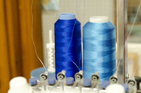 two blue and teal threads on interlocking machine thumbnail