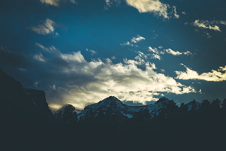 silhouette photography of mountain peak under alto cumulus clouds thumbnail