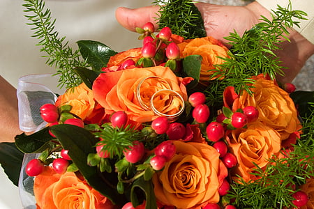 person holding orange petaled flowers thumbnail