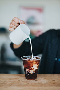 person pouring cream on coffee thumbnail