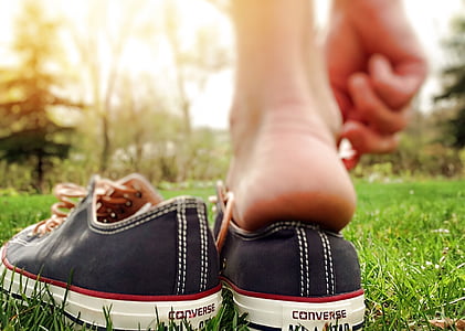 selective focus photography of black Converse lace-up low-top sneakers on green grass thumbnail