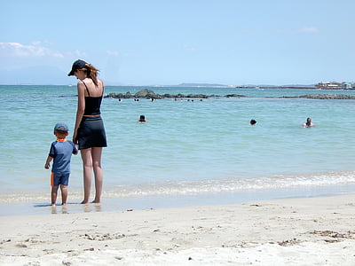 woman and child standing on seashore during daytime thumbnail
