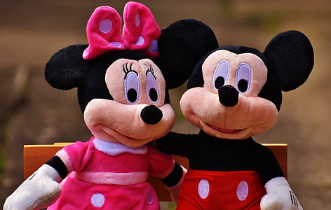 Mickey Mouse and Minnie Mouse plush toys sitting on brown wooden bench thumbnail