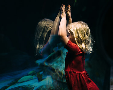 girl leaning on aquarium glass mirror thumbnail