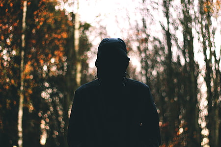person wearing hoodie surrounded by trees thumbnail