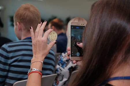 woman holding round gold-colored coin thumbnail