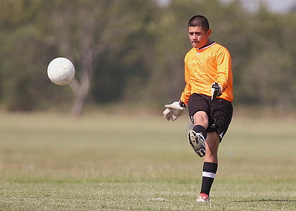man kicking white soccer ball on field thumbnail