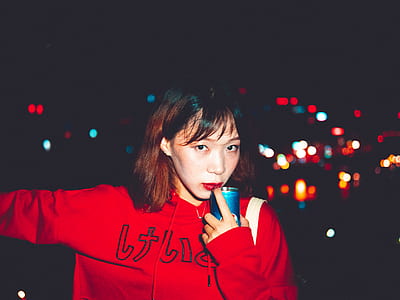 woman holding blue bottle while her index finger touching her red lips thumbnail