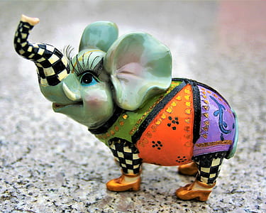 green and multicolored ceramic elephant figurine on gray surface thumbnail