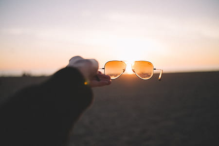 person holding orange aviator sunglasses thumbnail