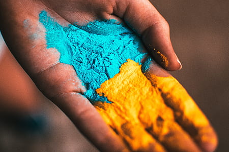 person holding yellow and teal powders thumbnail