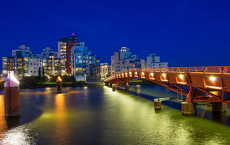 orange steel bridge connects city buildings thumbnail