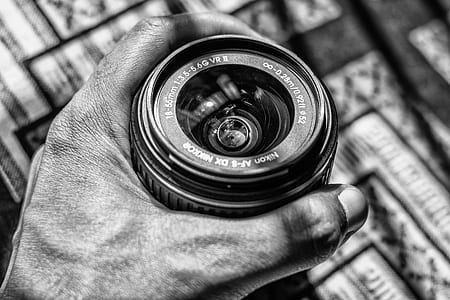Grayscale Photography of Person Holding Dslr Zoom Lens thumbnail