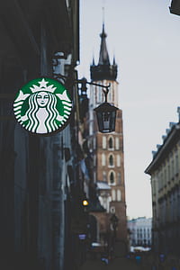 Starbucks logo hanging near sconce thumbnail