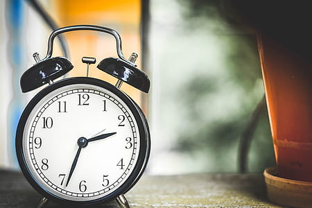 round black framed white analog alarm clock at 2:34 thumbnail