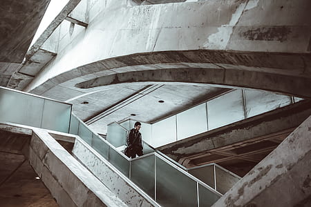 man walking down stairs near wall during daytie thumbnail