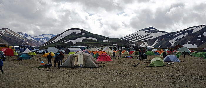 people standing beside tents near snow covered mountain under white clouds at daytime thumbnail