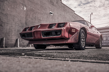 red Pontiac coupe during cloudy sky thumbnail