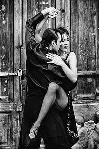 grayscale photo of man holding woman in dress thumbnail