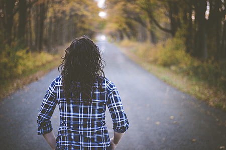 woman walking towards concrete road thumbnail