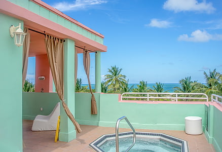 pink and teal building surrounded with coconut trees thumbnail