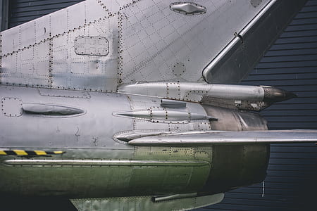 green and gray airplane near building thumbnail