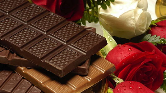 chocolate bars on top of red and white roses thumbnail