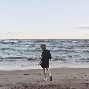 Woman Going Toward the Sea Under Clear Skies thumbnail