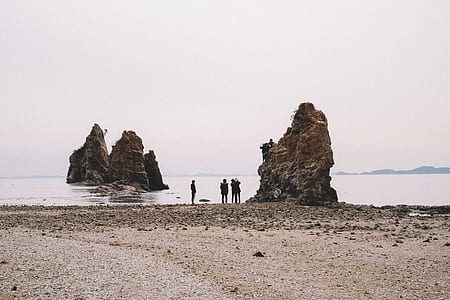 group of people gathering near brown rock thumbnail