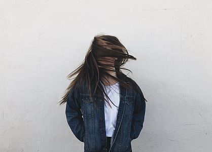 woman standing near white wall thumbnail