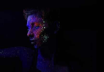 man with glow in the dark paint splattered on face thumbnail