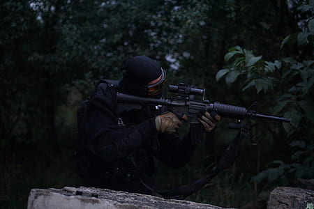 man holding rifle on forest thumbnail