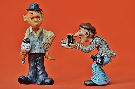 man holding microphone and man holding camera figurines thumbnail