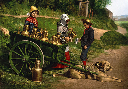 short-coated tan dog and green carriage beside three people standing at daytime thumbnail