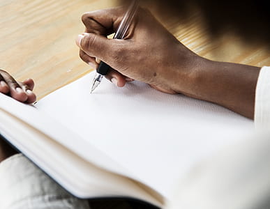 man writing on white book thumbnail