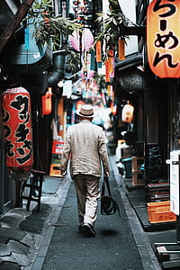 man walking on streets holding bag thumbnail