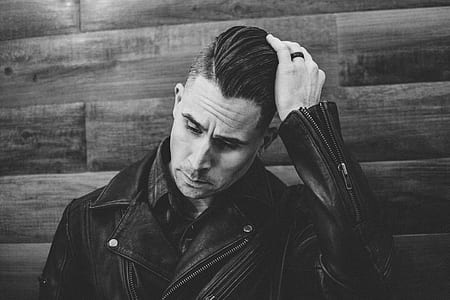 grayscale photo of man holding hair thumbnail