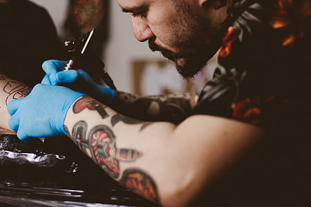 man tattooing nape of person thumbnail