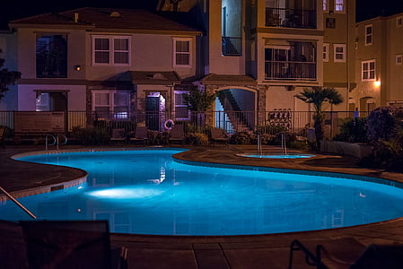 white concrete house with swimming pool during nighttime thumbnail