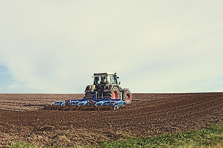 tractor pulling cultivator during daytime thumbnail