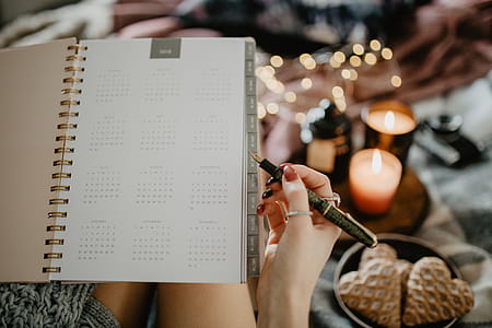 Writing in a notebook lying in bed, with coffee, candles, and gingerbreads thumbnail