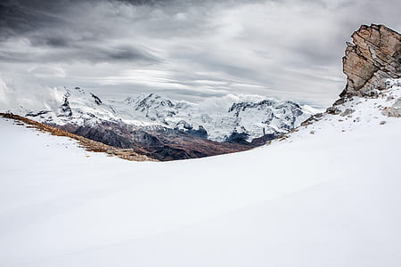 snow-covered mountain under cloudy skies thumbnail