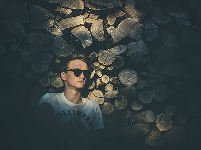 man standing in front of logs thumbnail